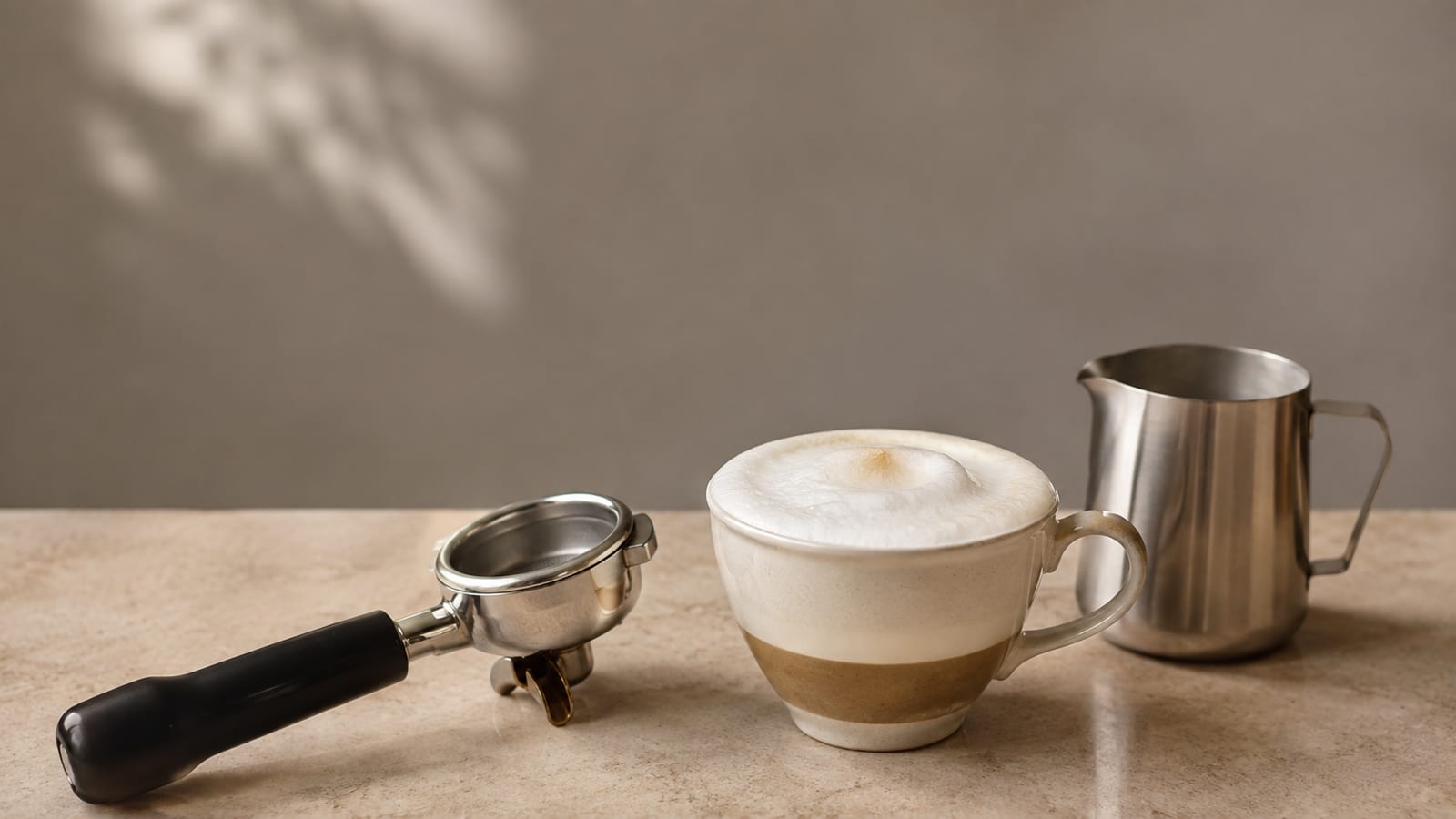 Layered Wiener Melange with espresso, steamed milk, and soft foam beside coffee equipment
