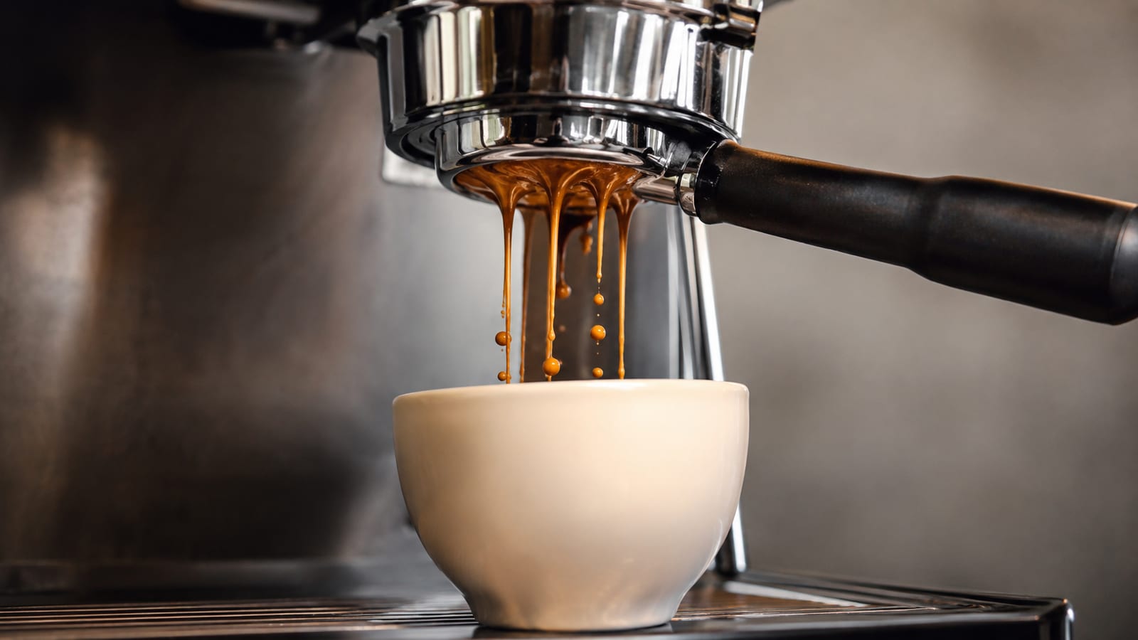 Bottomless portafilter revealing irregular espresso streams during a visibly channeling shot