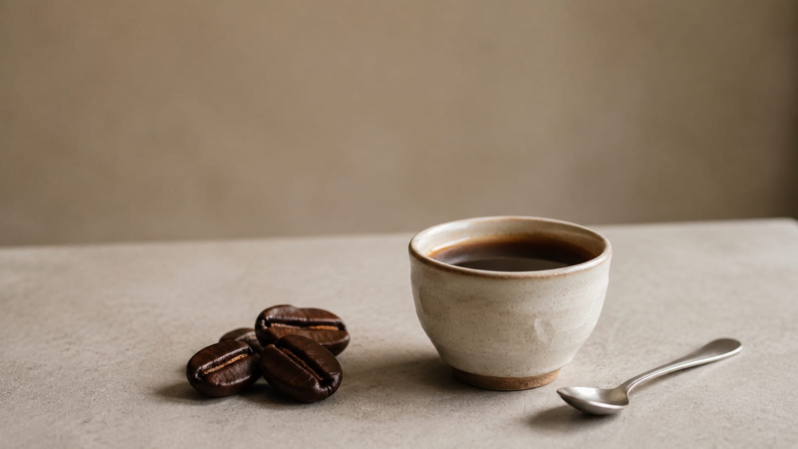 Freshly brewed Maragogipe coffee in a ceramic cup beside oversized roasted beans